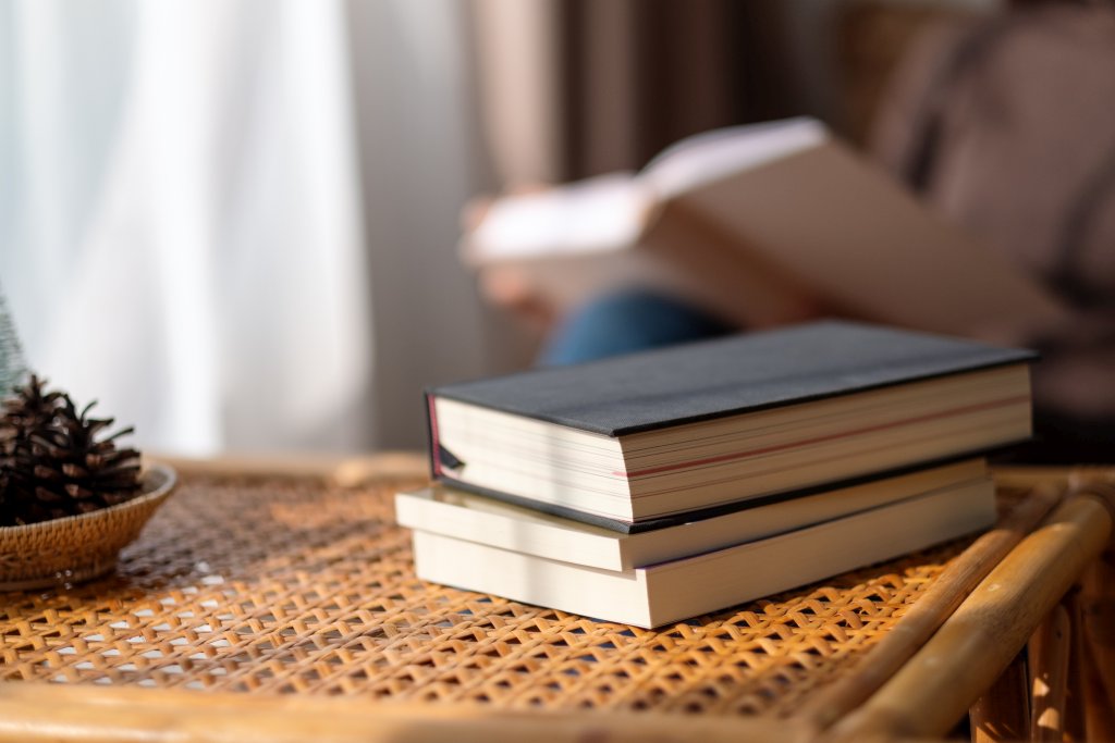 Closeup image of books on wooden table with blurred of a woman r
